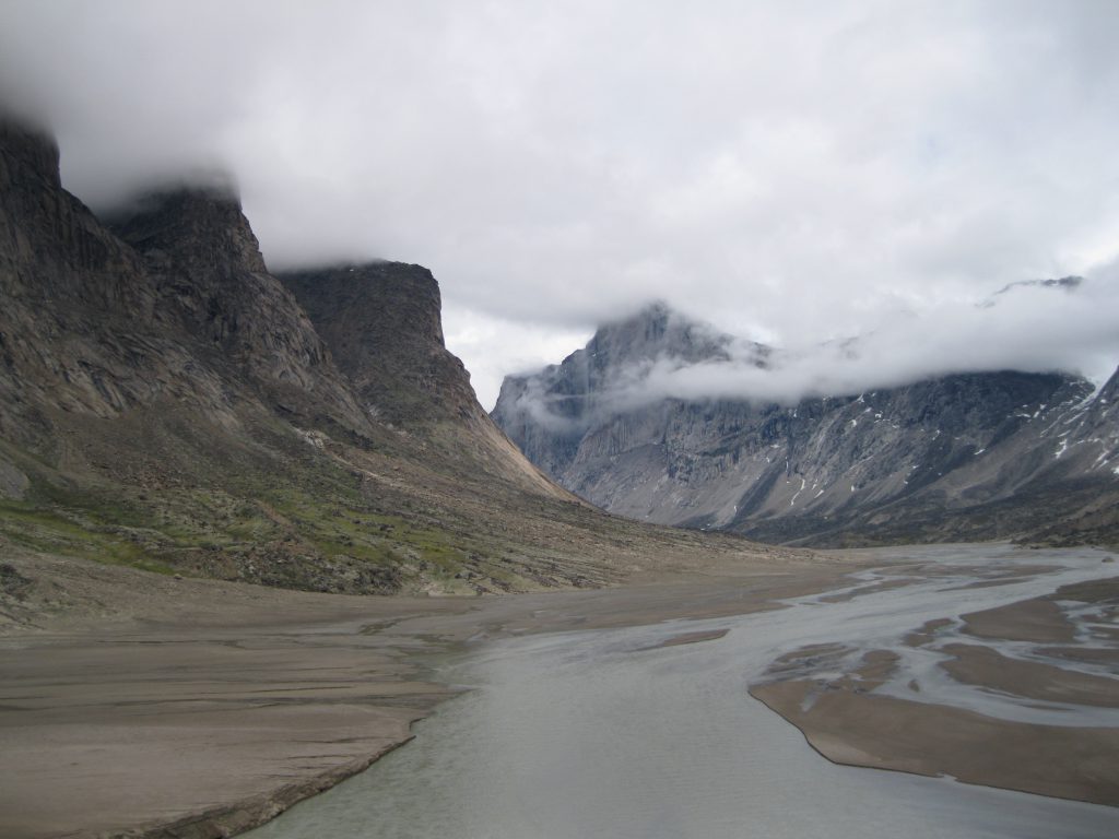 Three peaks and Mount Thor in the mist, the Weasel River and Akshayuk Pass as seen from the top of the Windy Lake Moraine